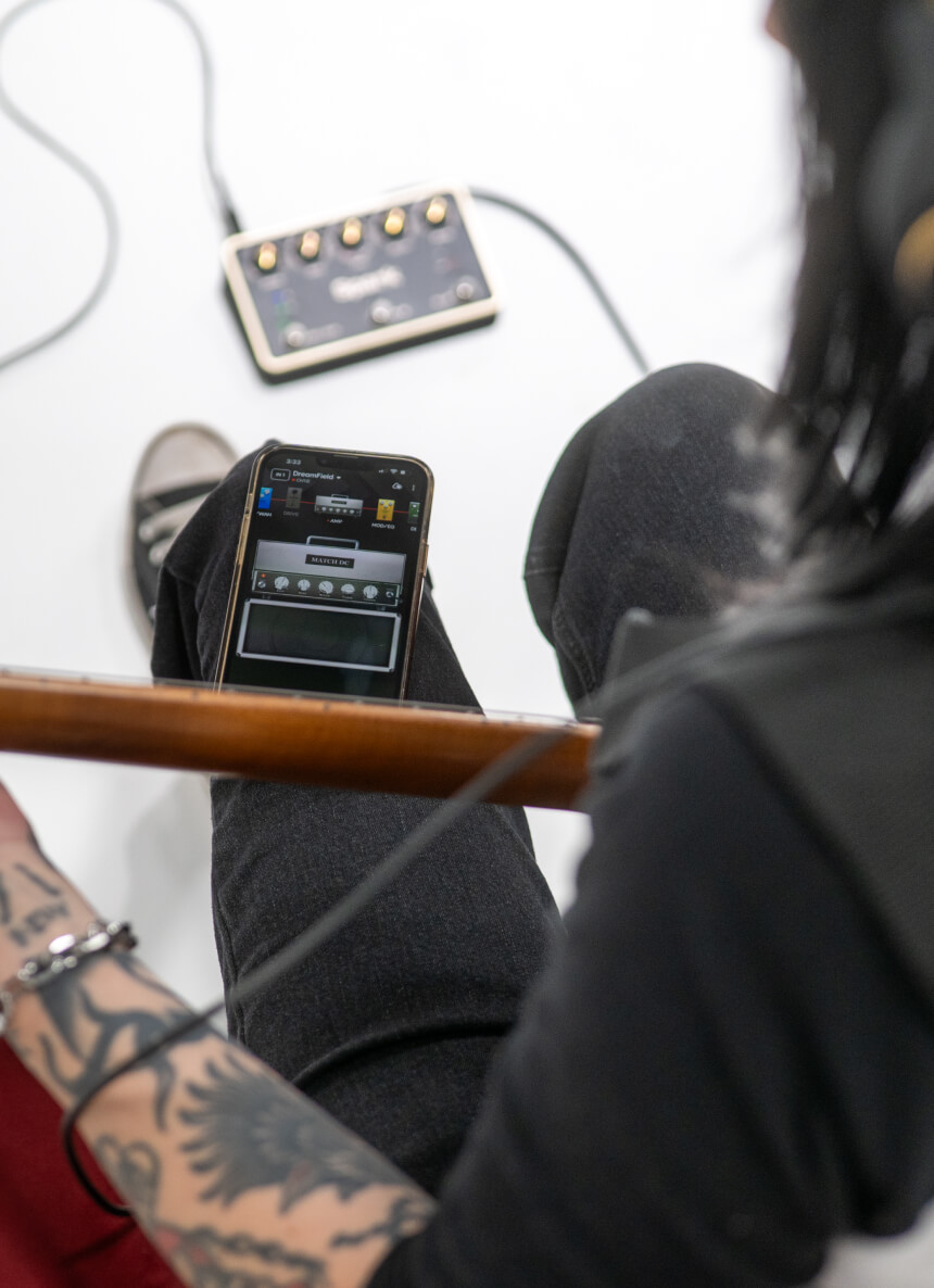 Guitarist jamming along with the Spark app on their phone and Spark PEDAL